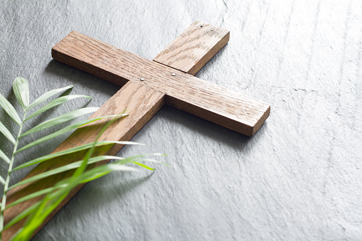 Easter wooden cross on black marble background religion abstract palm sunday concept closeup